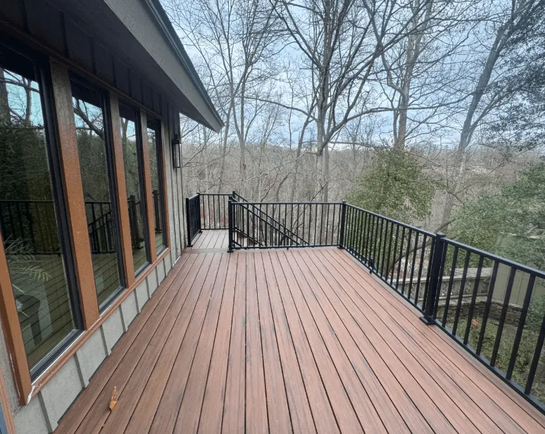 Composite deck with black aluminum railing overlooking woodland — JHG Contracting LLC serving Summers, AR