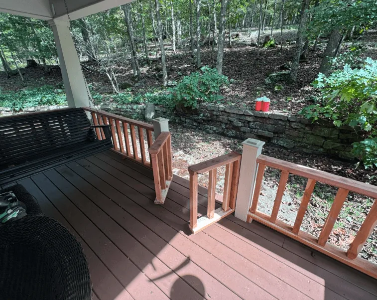 Covered composite deck with cedar railings and porch swing — JHG Contracting LLC serving Gentry, AR